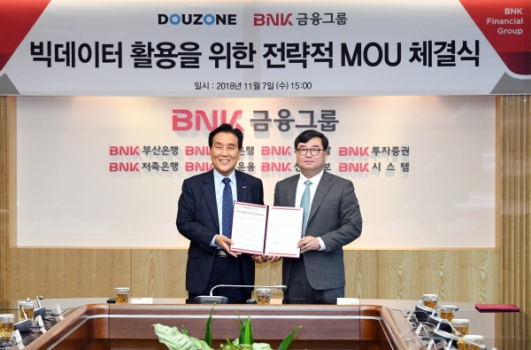 더존비즈온 김용우 회장(오른쪽)과 BNK금융그룹 김지완 회장이 양해각서를 교환하고 있다