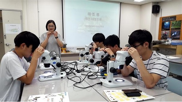 청소년 생물자원교실에서 해조류 표본을 현미경으로 관찰하고 있다.