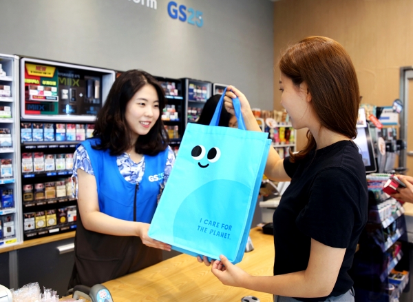 고객이 GS25 매장에서 친환경 대여쇼핑백을 구매하고 있다