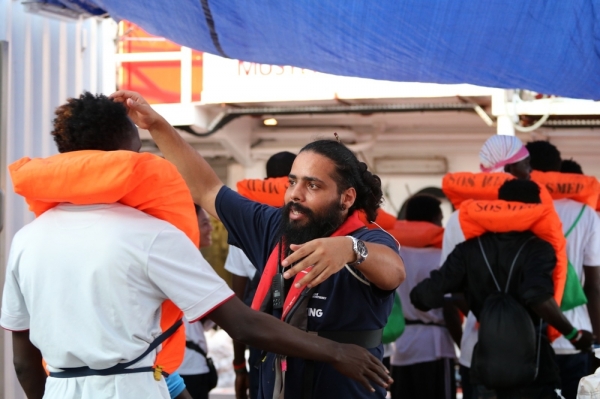 국경없는의사회 직원이 몰타에 하선하기 전 몰타 군 선박으로 이동하는 생존자를 포옹하며 인사하고 있다
