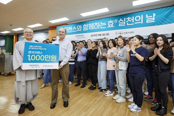 한국지멘스 더 나눔 봉사단이 서울 종로구 서울노인복지센터를 찾아 후원금 1000만원을 전달하고 있다