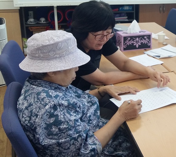 이영진씨가 서울 마포구 치매센터에서 치매경증 어르신에게 치매예방을 위한 인지프로그램을 실시하고 있다.