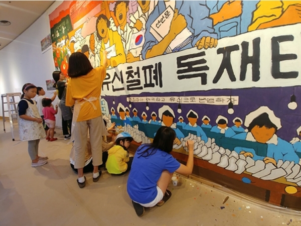 걸개그림 완성에 참여한 시민들이 작업에 열중하고 있는 모습.(사진=부마민주항쟁기념재단)