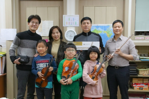 낙원악기상가가 문화소외계층 아이들에게 반려악기를 선물하고 기념촬영을 하고 있다