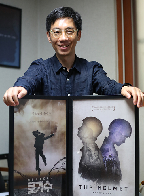 정인석 아이엠컬처 대표가 대표작 ‘로기수’, ‘헬멧’을 설명한 후 포스터와 함께 기념촬영하고 있다.