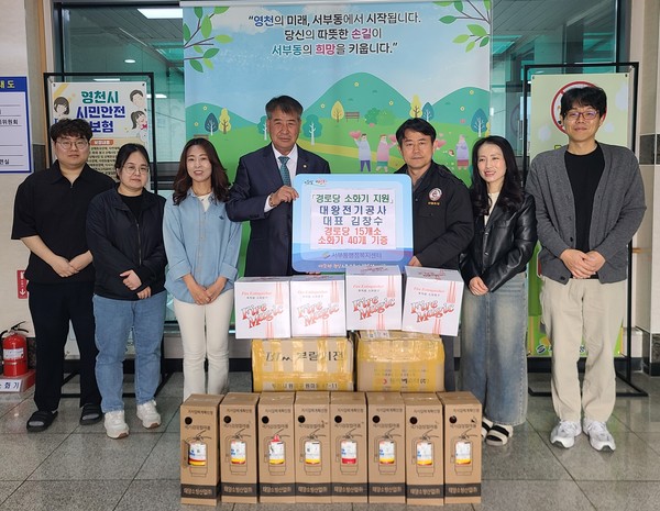 서부동 지역사회보장협의체 김창수 위원이 관내 경로당에 소화기 40대를 지원하고, 직원들과 기념촬영을 하고 있다.[영천시 제공]